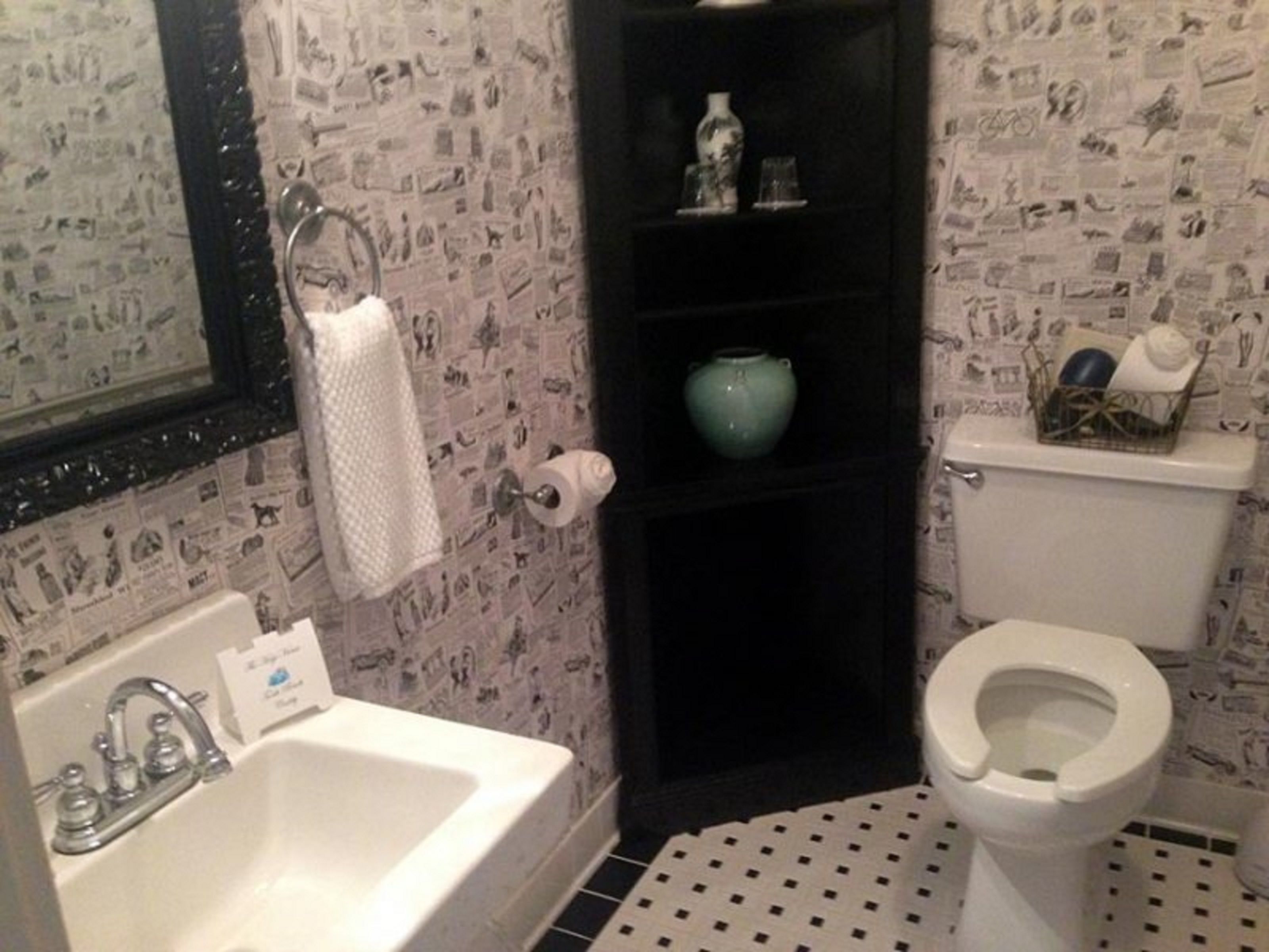 A bathroom with a sink, toilet, and shelves with toiletries.