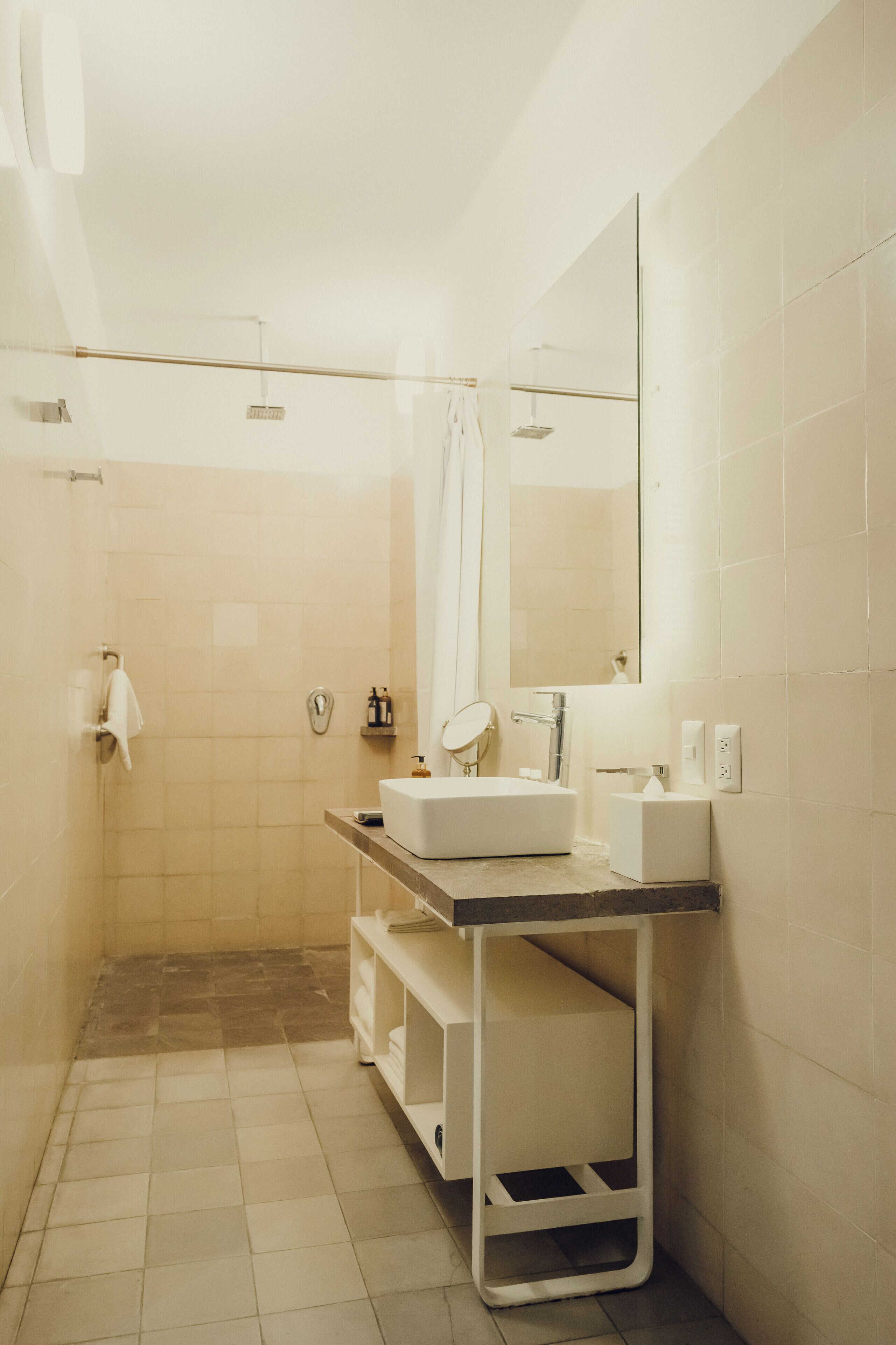 A modern bathroom with a walk-in shower, a sink, a mirror, and a towel rack.