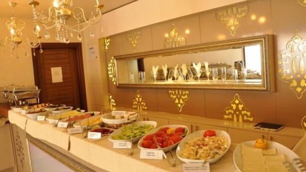 A buffet area with various food items and a mirror above the counter. - Grand Anzac Hotel (Çanakkale)