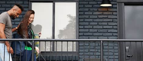 A building with a dark brick facade, a window, and a door.