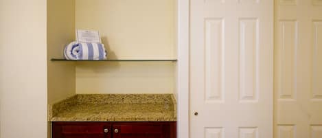 A kitchen with a granite countertop, a red cabinet, and a white door.