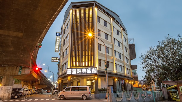 A multi-story hotel with a modern design, featuring a prominent entrance and a visible sign in a foreign language. - Luckynews Classic Hotel (Taoyuan City)