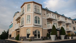 A multi-story hotel with a corner entrance, large windows, and balconies.