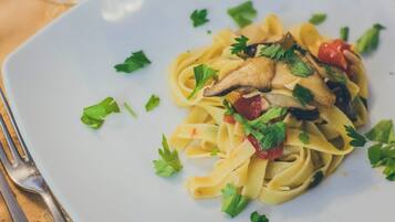 Un plato de pasta con champiñones y perejil.