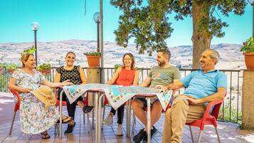 Un grupo de personas sentadas a una mesa con vistas al campo.