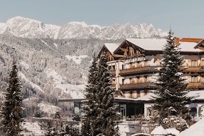 A hotel with a traditional Alpine architectural style, featuring wooden balconies and a mountain backdrop. - Oberforsthof (Sankt Johann im Pongau)