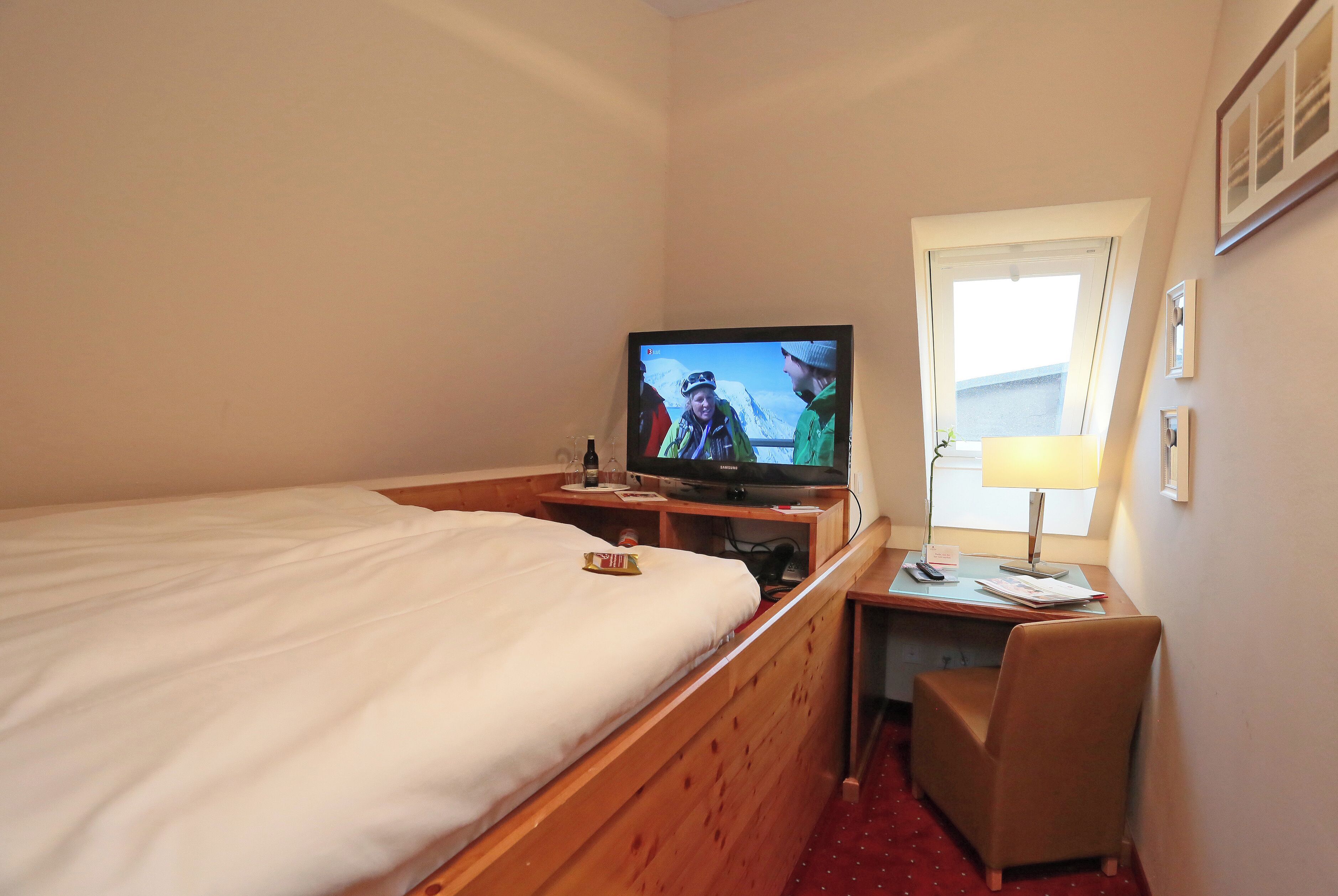 Une chambre d’hôtel équipée d’un lit, d’une télévision, d’un bureau et d’une chaise.