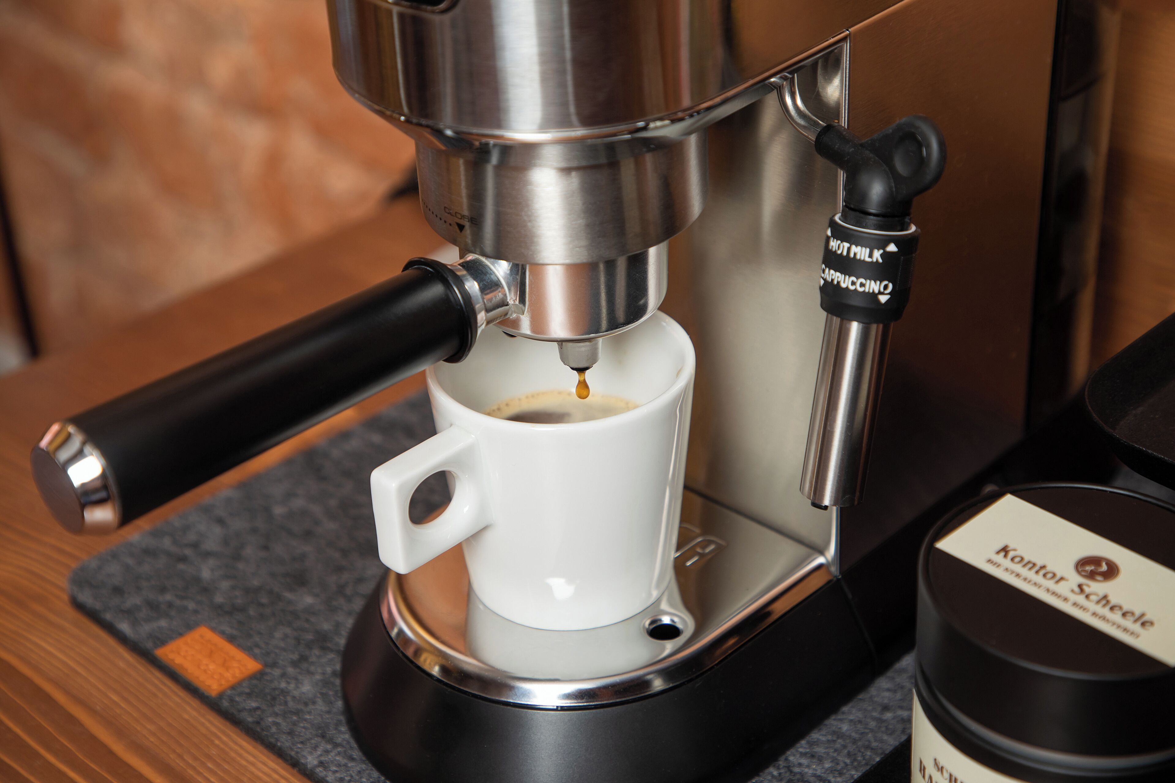 Eine Kaffeemaschine gibt Espresso in eine Tasse ab.