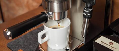 Eine Kaffeemaschine gibt Espresso in eine Tasse ab.