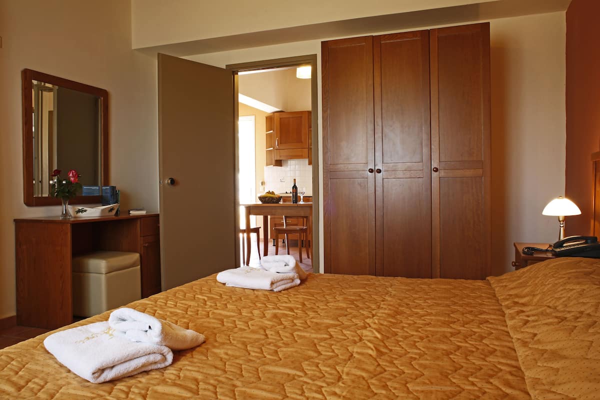 A hotel room with a bed, a desk, a chair, and a wardrobe.