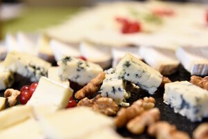 A variety of cheeses and nuts on a platter.