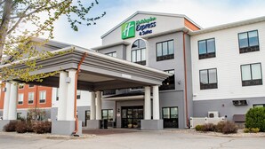 A Holiday Inn Express & Suites building with a covered entrance, multiple windows, and a clear sign indicating the name. - Holiday Inn Express and Suites Mason City by IHG (Mason City)