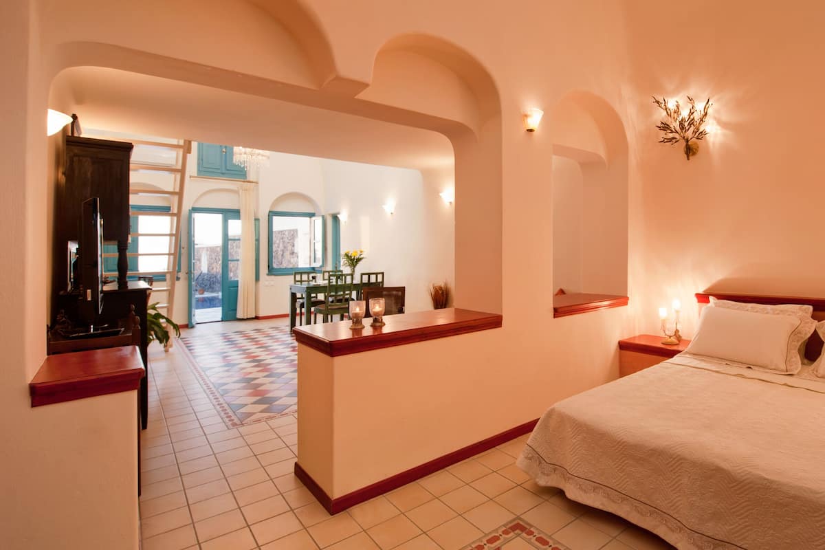 Une chambre d’hôtel avec un grand lit, un bureau et une vue sur le couloir.