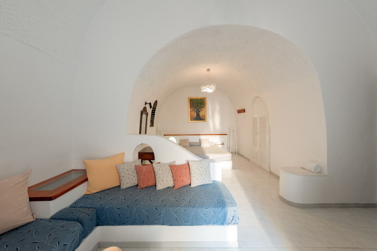 Une chambre à coucher comprenant un lit, un canapé, un escalier et une salle de bain.