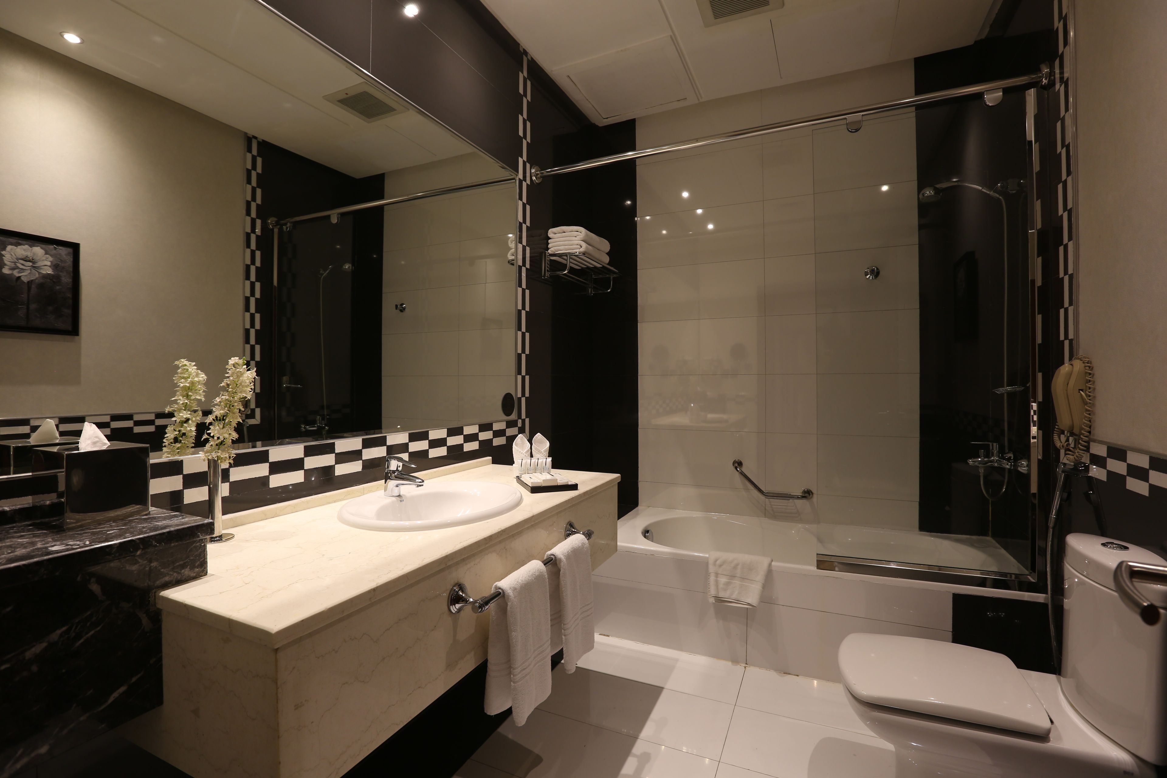A modern bathroom with a glass-enclosed shower, a bathtub, and a toilet.