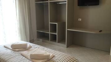 A bedroom with a bed, a wardrobe, and a TV.