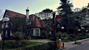 Un bâtiment traditionnel doté d’une cheminée imposante, entouré de jardins bien entretenus et d’un lampadaire.