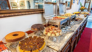 Un bufé con distintos alimentos y un espejo grande encima.