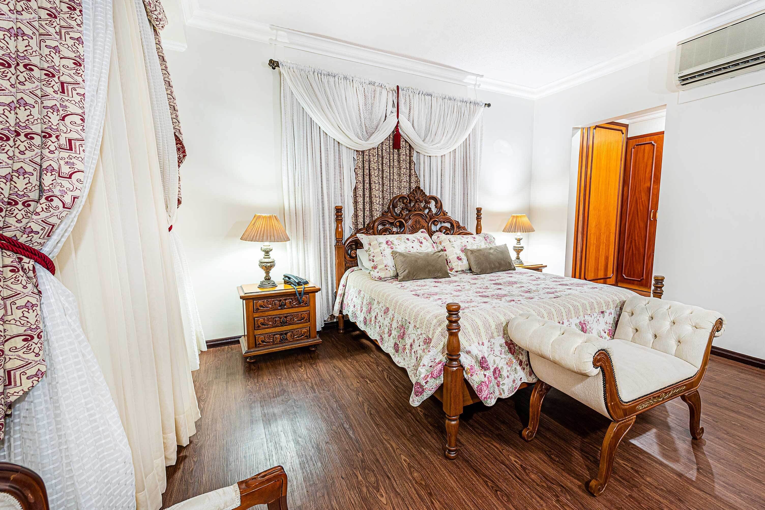 A bedroom with a wooden bed, a nightstand, a chair, and a wardrobe.