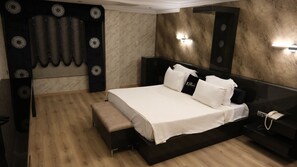 Relax in a stylish room with a large bed, bedside table, and bench at the foot of the bed.