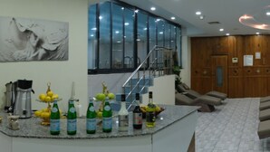A hotel lobby with a reception desk, a staircase, and a green door. - Ravanda Hotel (Gaziantep)