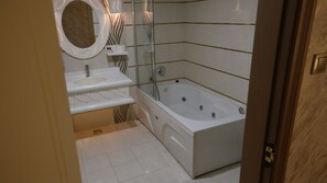 Bathroom features a bathtub, sink, and glass-enclosed shower.