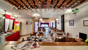 A dining area with multiple tables, chairs, and a buffet setup. - Hotel Internacional (Buenos Aires)