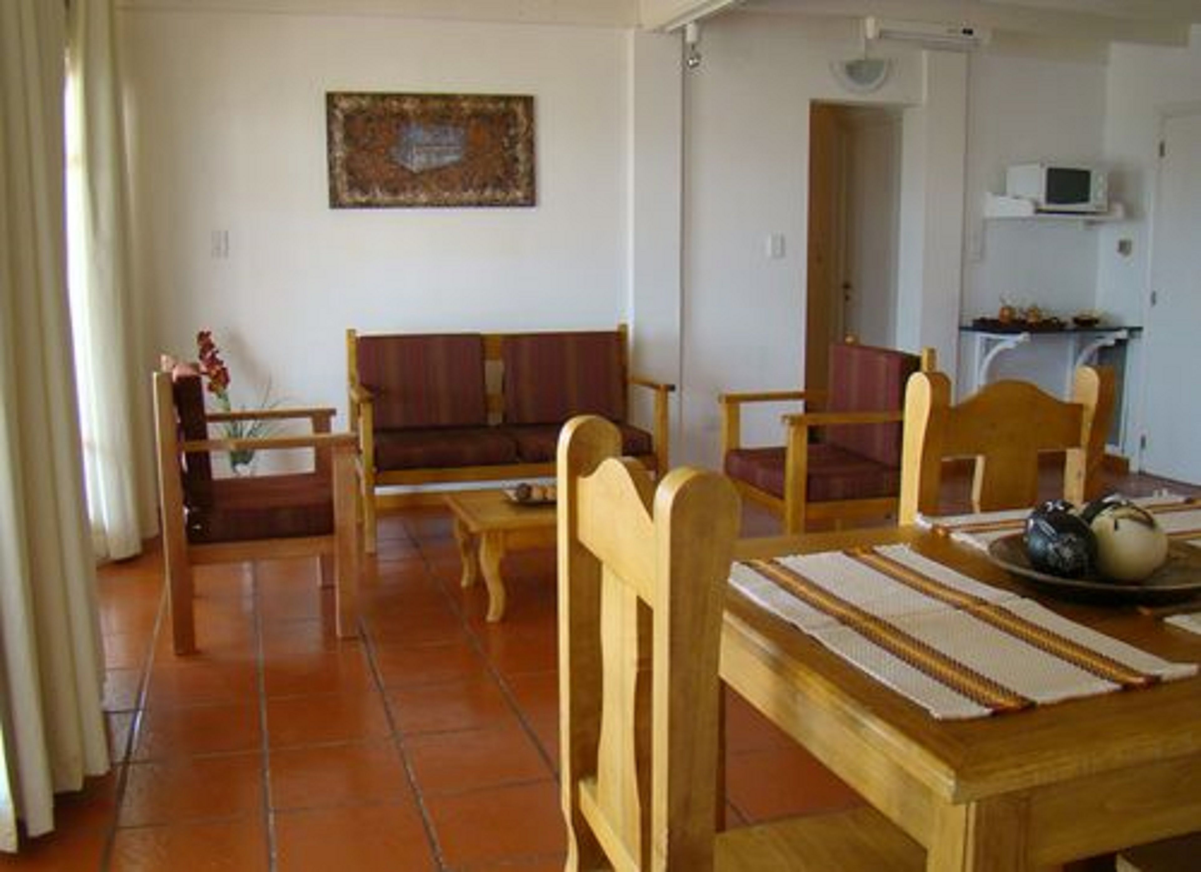 Un salon avec un canapé, des fauteuils, une table et un téléviseur.