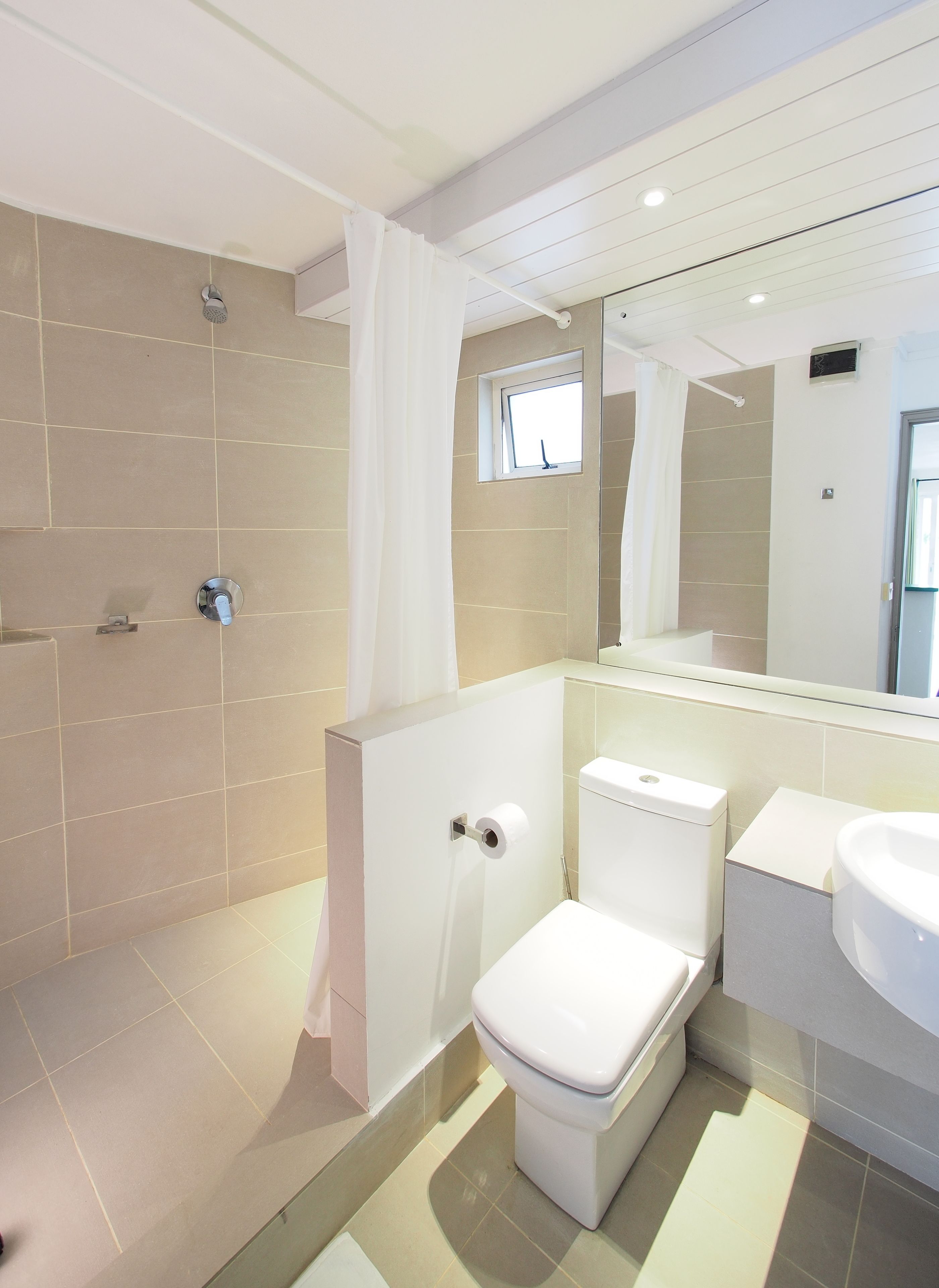 A modern bathroom with a shower, toilet, and sink.