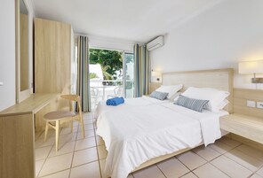 Una habitación de hotel con una cama, un escritorio y una silla.