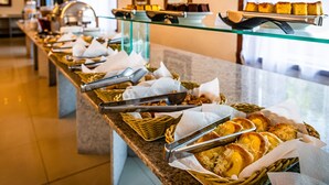 Una mesa de buffet con diversos alimentos y utensilios de servicio.