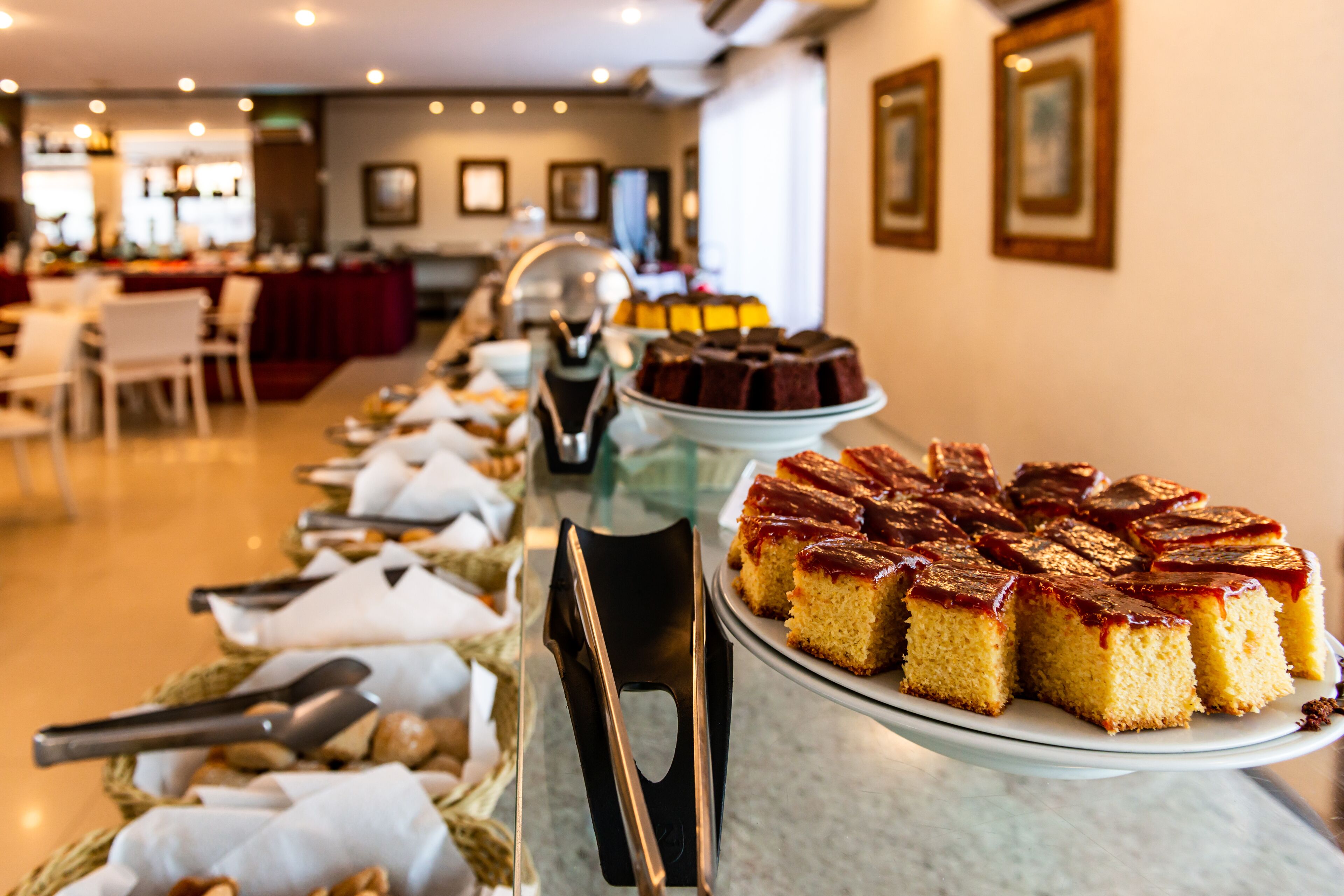Un bufé con diversos postres, incluyendo un pastel con cobertura de caramelo, dispuesto en un mostrador.