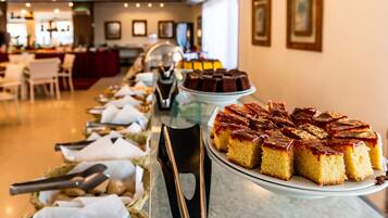 A buffet with various desserts, including a cake with a caramel topping, arranged on a counter.