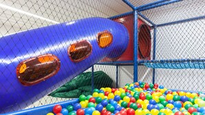 Un área de juegos con una piscina de pelotas y un tobogán.