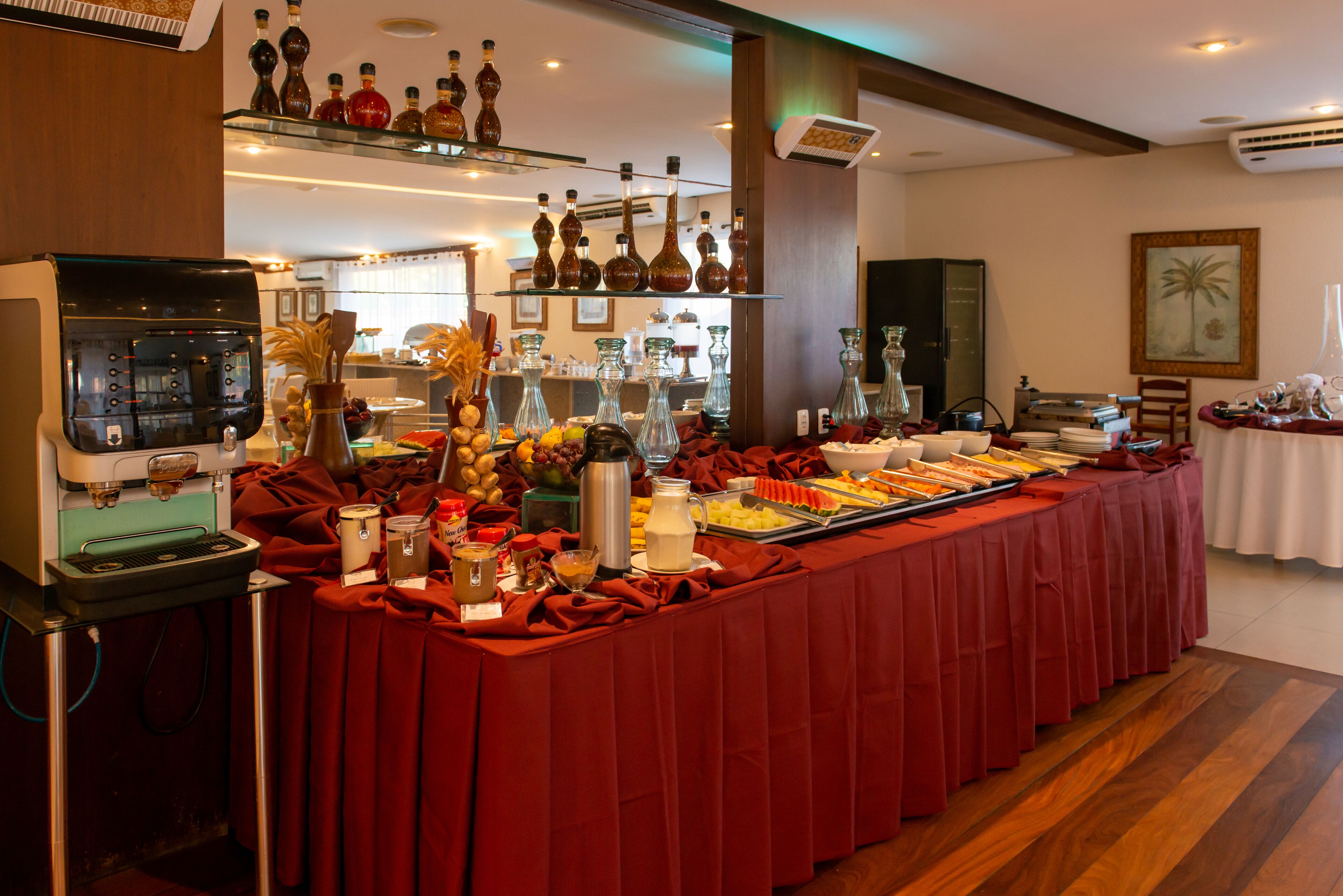 A buffet setup with a coffee machine, various food items, and decorative vases.