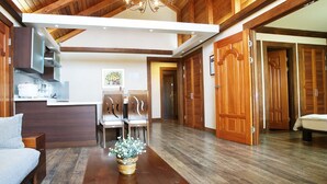 A modern interior with a wooden ceiling, a dining area with chairs, a sofa, and a bed. - Aewol ParkHill Village (Jeju City)
