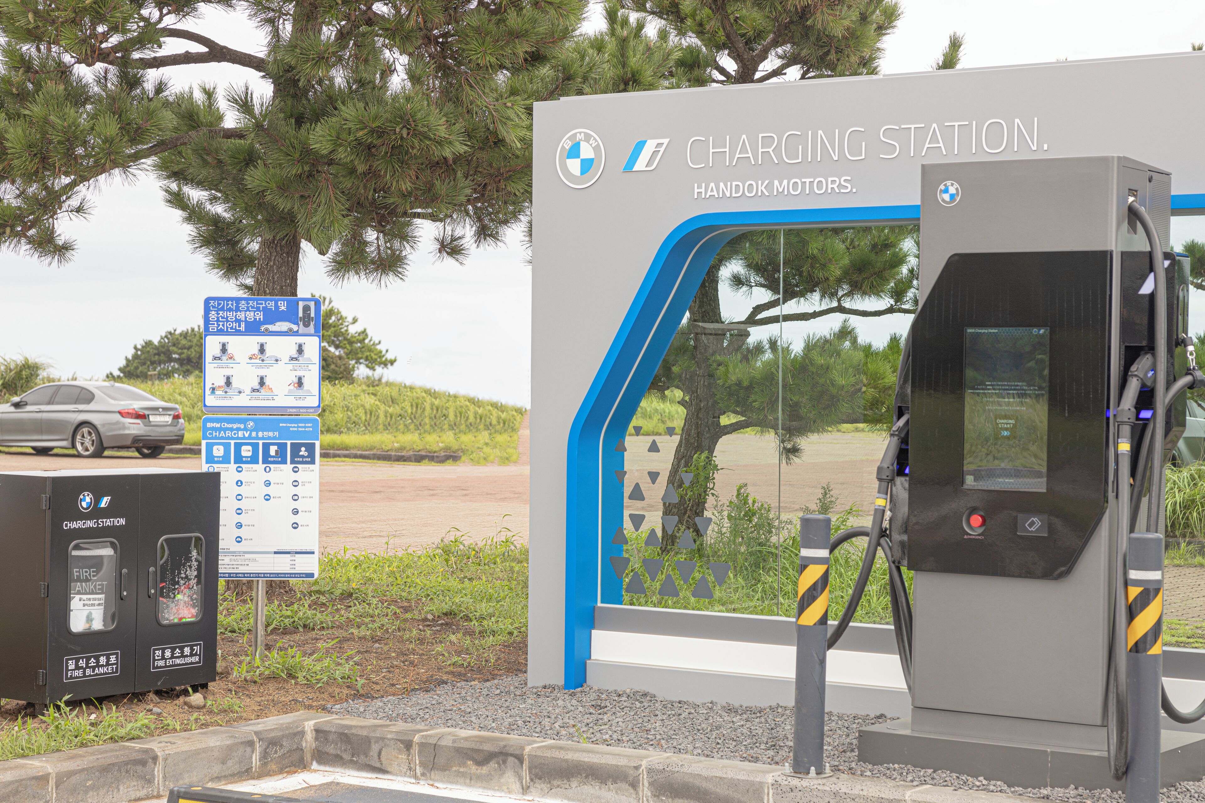 A BMW charging station with a sign indicating it's a Handok Motors charging station.