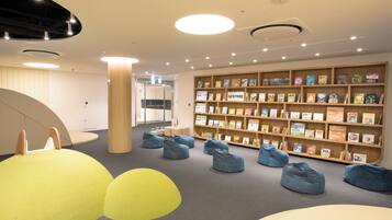 A children's library with bookshelves, bean bags, and a circular seating area.