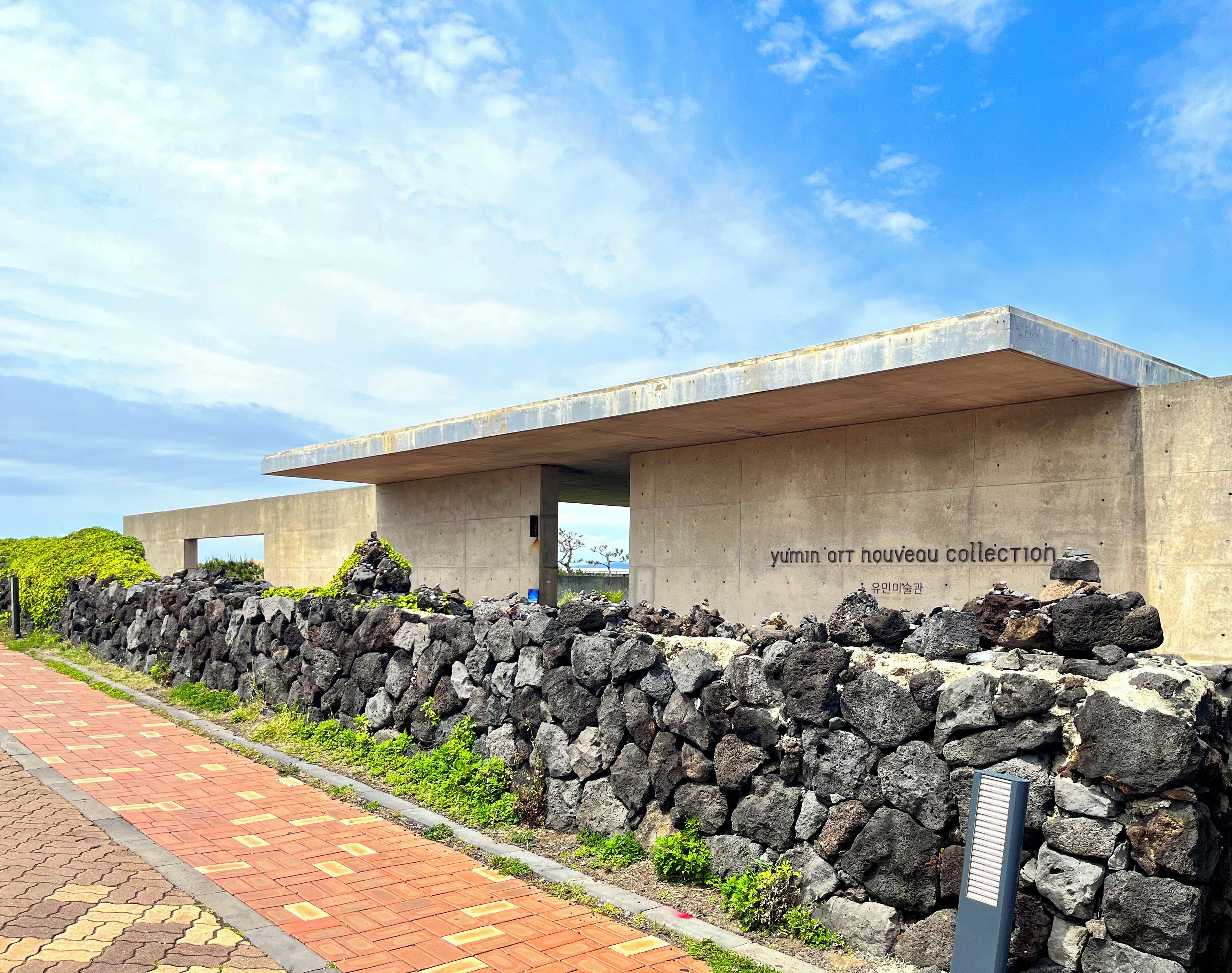 A modern building with a concrete facade and a stone wall in front.