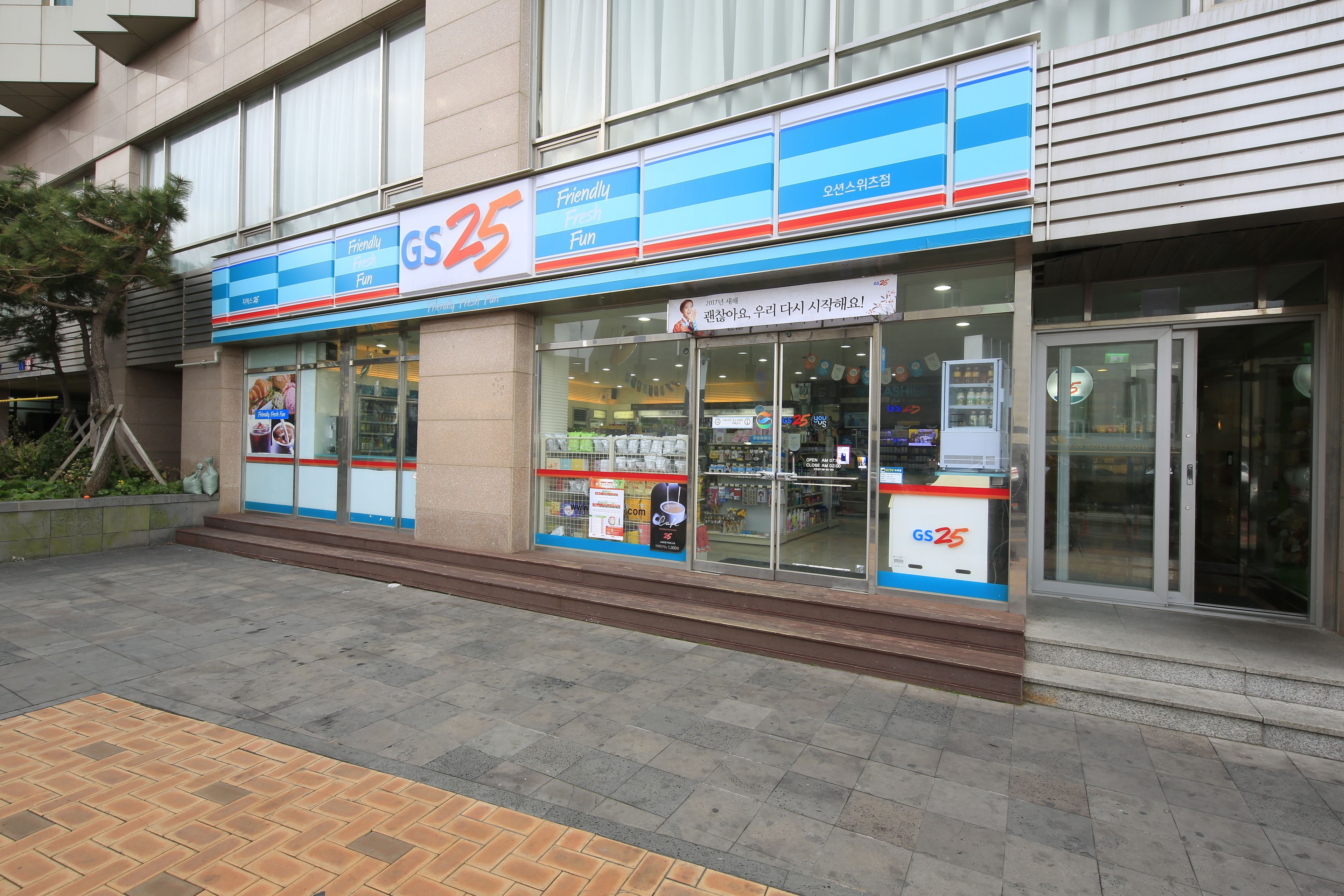 A storefront with a large sign reading "GS25" and "Friendly Fresh Fun".