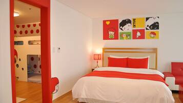 Cozy retreat with a large bed, colorful artwork, and a child's play area nearby.