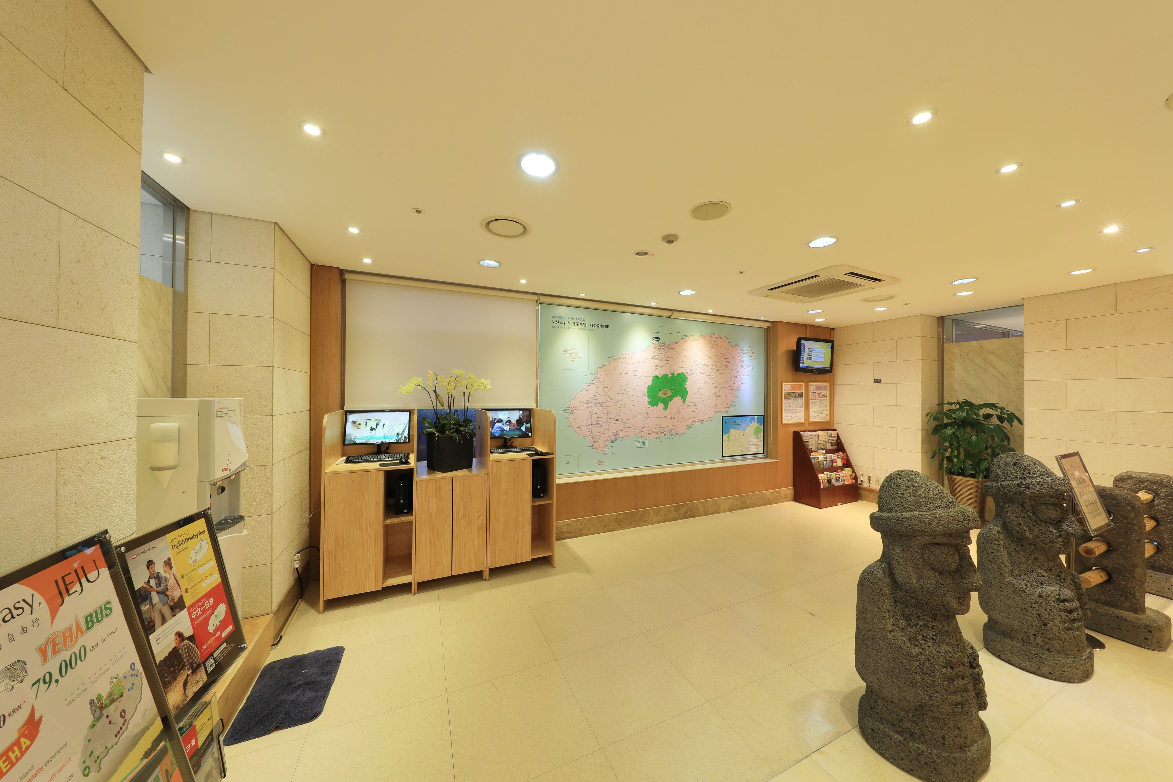 A reception area with a wooden desk, a map on the wall, and stone sculptures.