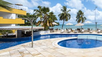 Una piscina al aire libre, sombrillas, tumbonas