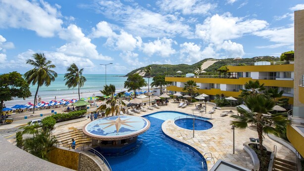 A resort with a large pool, beach umbrellas, and a view of the ocean. - Aquaria Natal Hotel (Natal)