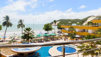 Relax by the infinity pool overlooking the ocean and beach.