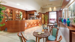 A hotel lobby with a bar area, seating arrangements, and a reception desk. - Palace Hotel (Civitanova Marche)
