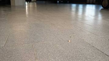 Un aparcamiento con suelo de baldosas y columnas.