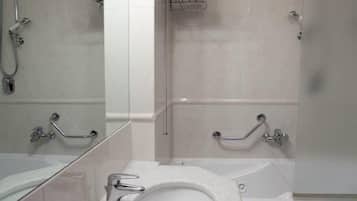 A modern bathroom with a large mirror, white fixtures, a bathtub, and a shower.