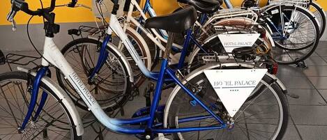 A row of bicycles parked in a designated area with a yellow and gray wall in the background.