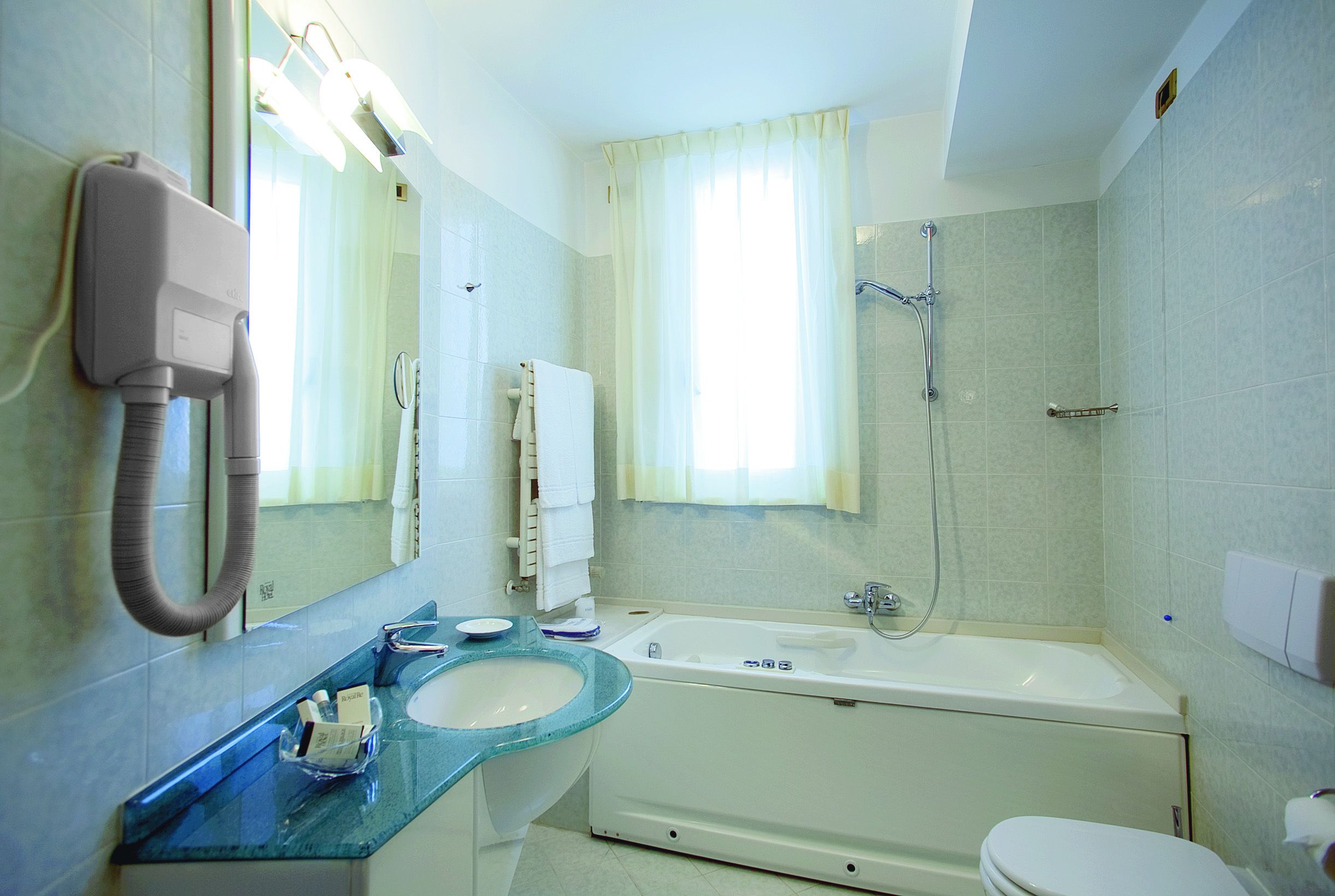 Un baño con lavabo, espejo y bañera.